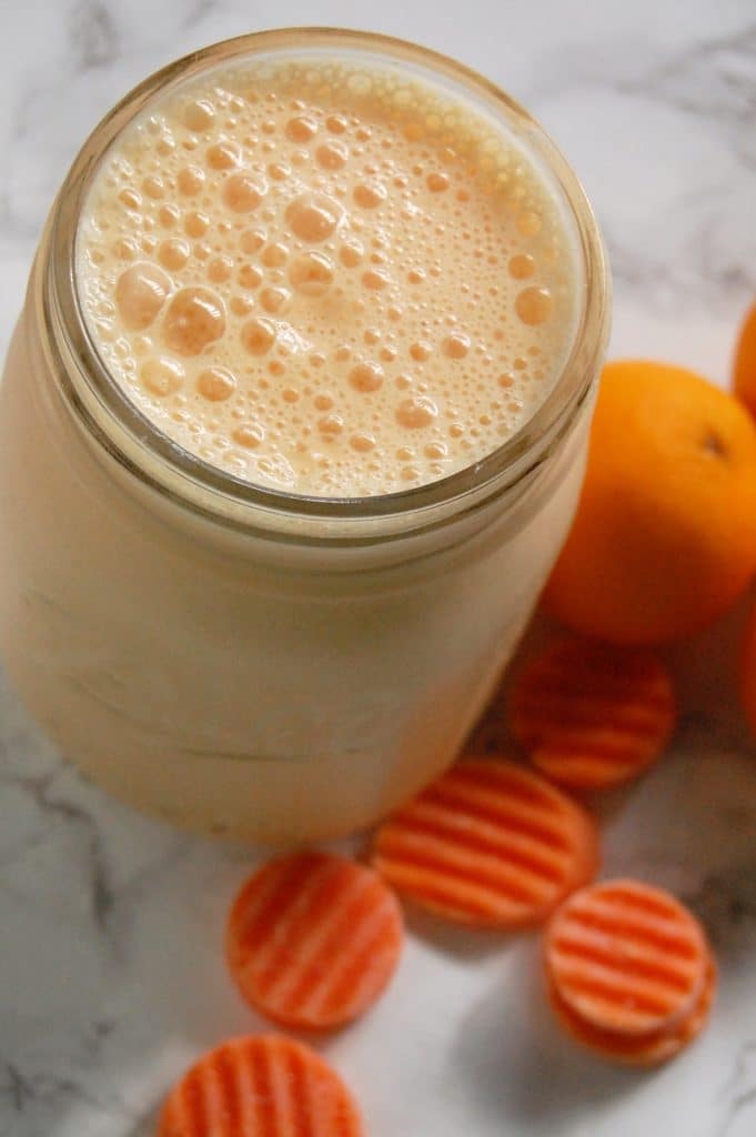 A frothy pale orange creamsicle clementine smoothie in a mason jar