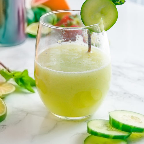 Stemless wine glass of cucumber mint agua fresca with cucumber and mint garnish.