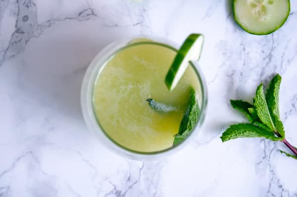 Overhead shot of a cucumber mint agua fresca with cucumber and mint garnish.