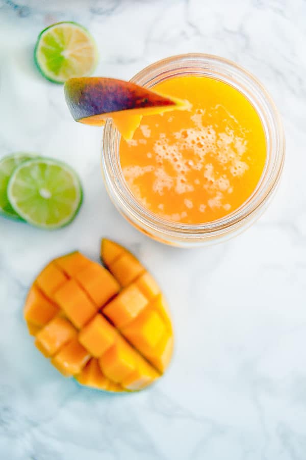 Overhead view of mango agua fresca with fresh sliced mango on the side.