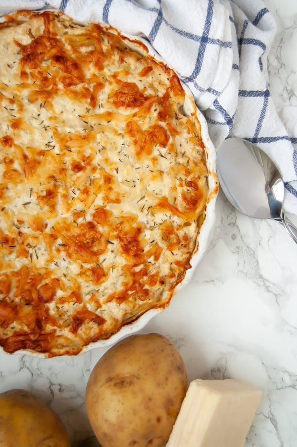 Thinly sliced yukon gold potatoes baked with a greek yogurt-based cream sauce & cheese for a lighter scalloped potato gratin. A healthy holiday side dish!