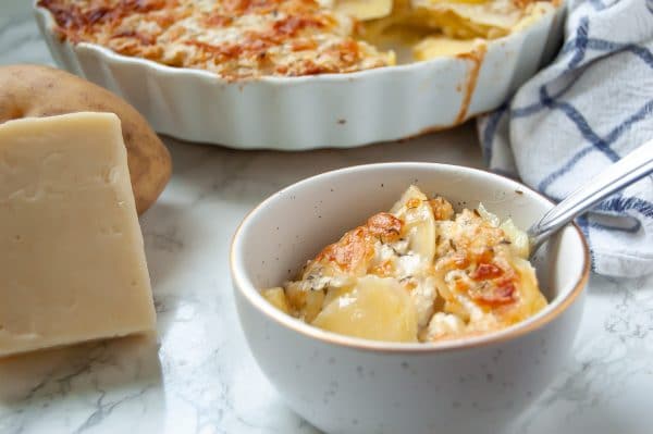 Thinly sliced yukon gold potatoes baked with a greek yogurt-based cream sauce & cheese for a lighter scalloped potato gratin. A healthy holiday side dish!