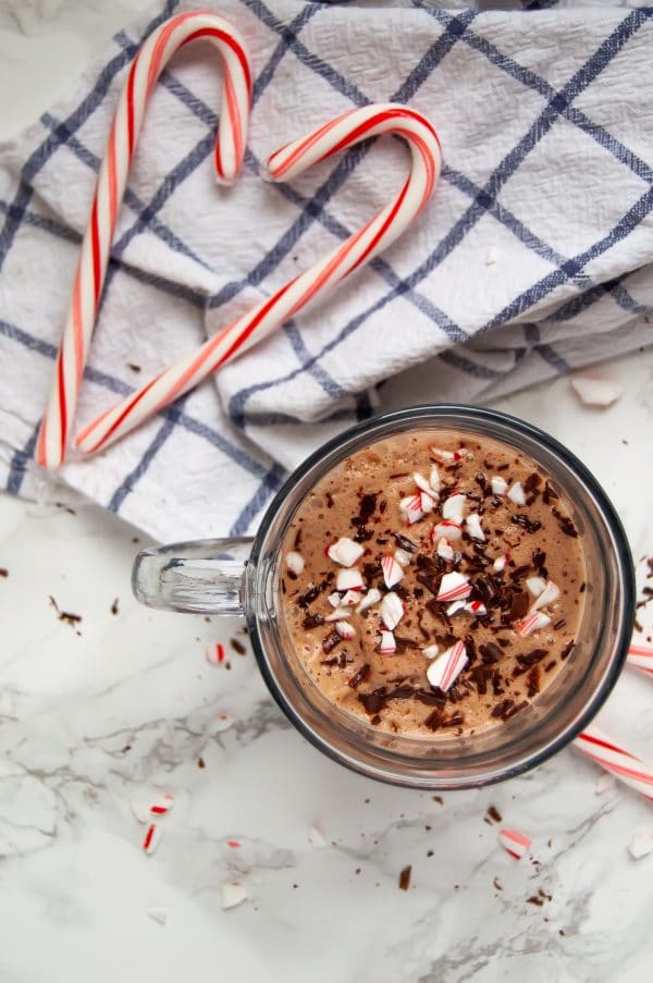 A flatlay picture of dairy-free peppermint hot chocolate with a heart made out of candy canes.