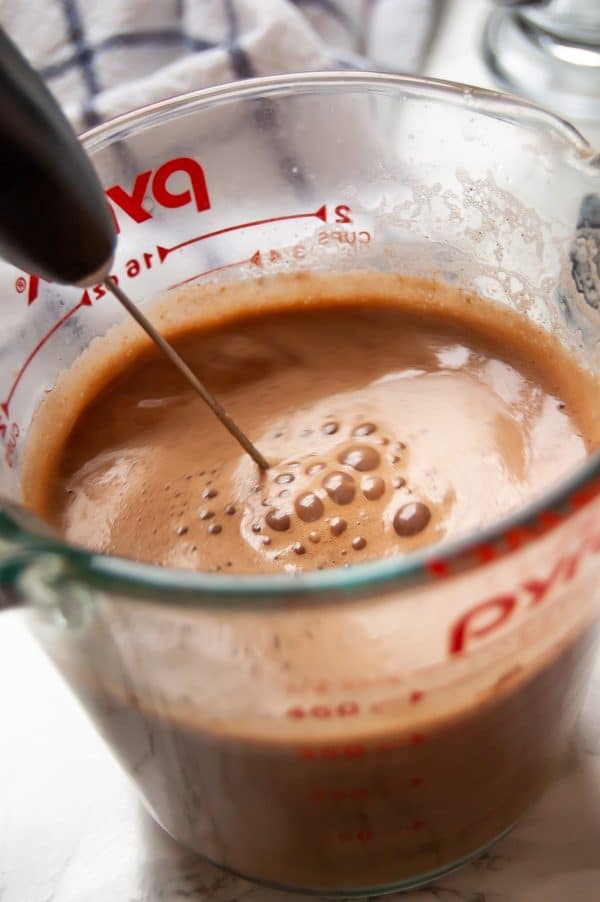 Peppermint hot chocolate being mixed with a milk frother.