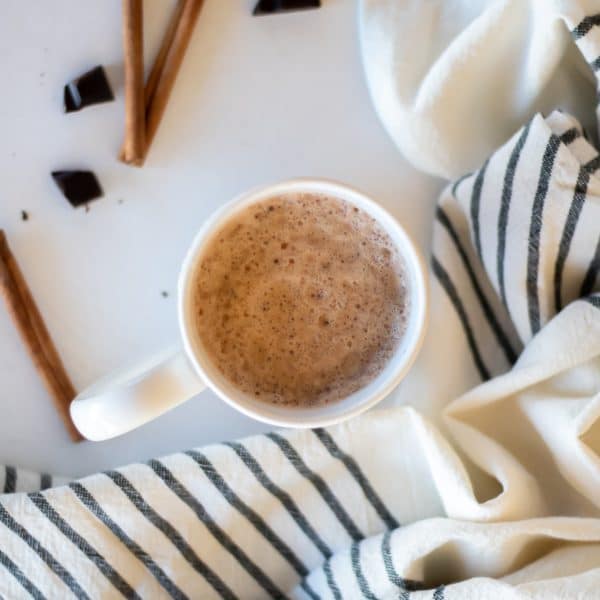 An overhead shot looking down at a mug of chocolate chai tea that is foamy and swirly on top.