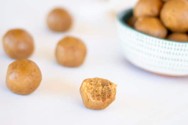 No bake peanut butter energy balls with a bite taken out of one.