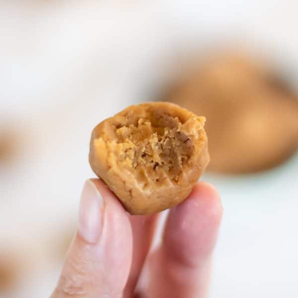 A bite taken out of a no bake peanut butter energy ball