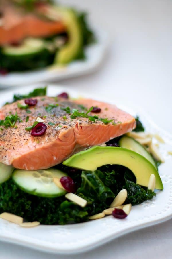Instant Pot Salmon over a massaged kale salad with avocado, cucumbers, dried cranberries, and almond slivers.