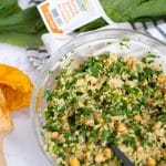 a glass bowl of chickpea quinoa salad with turnip greens with Nature's Greens turnip greens beside it.