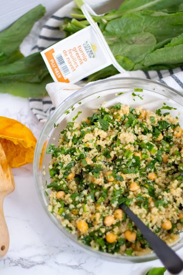 a glass bowl of chickpea quinoa salad with turnip greens with Nature's Greens turnip greens beside it.