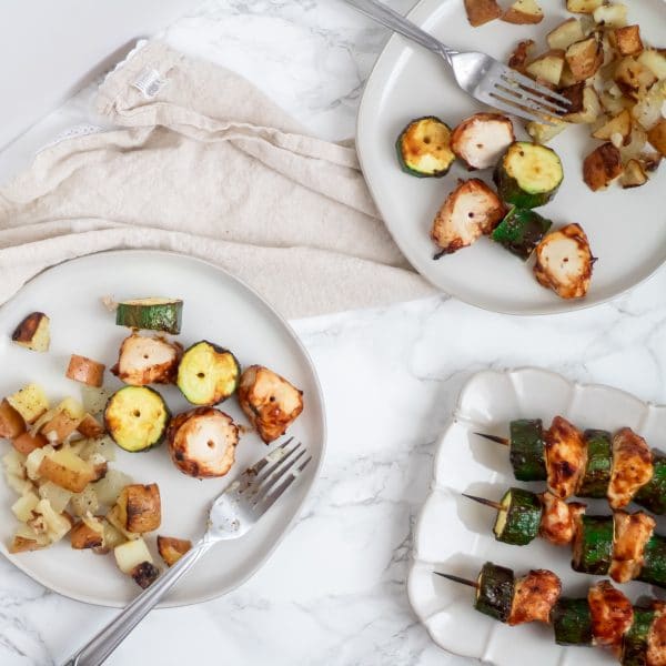 square image of plates of bbq chicken skewers with zucchini