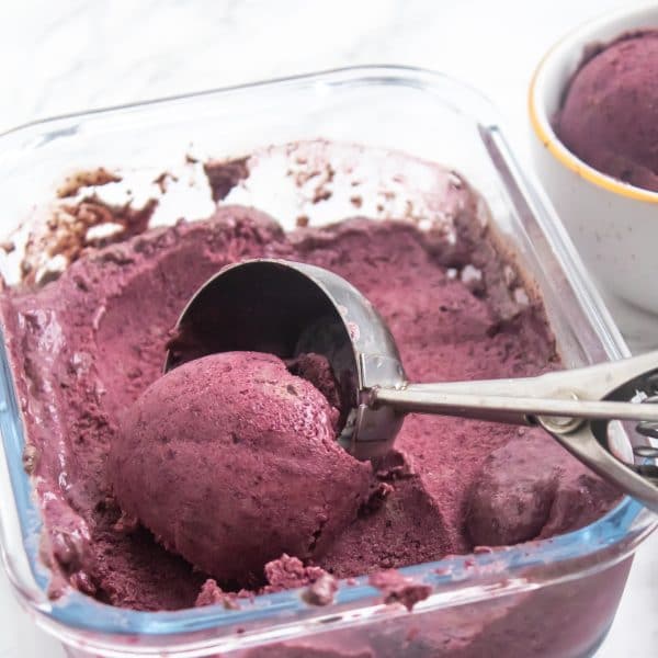 scooping blueberry avocado nice cream to show creamy texture