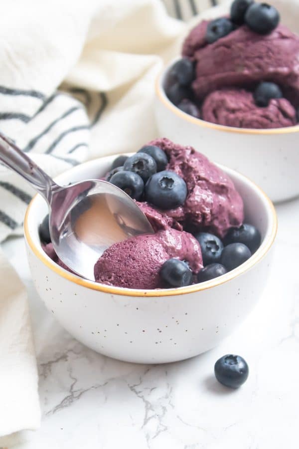 a spoon scooping a creamy bite of blueberry avocado nice cream