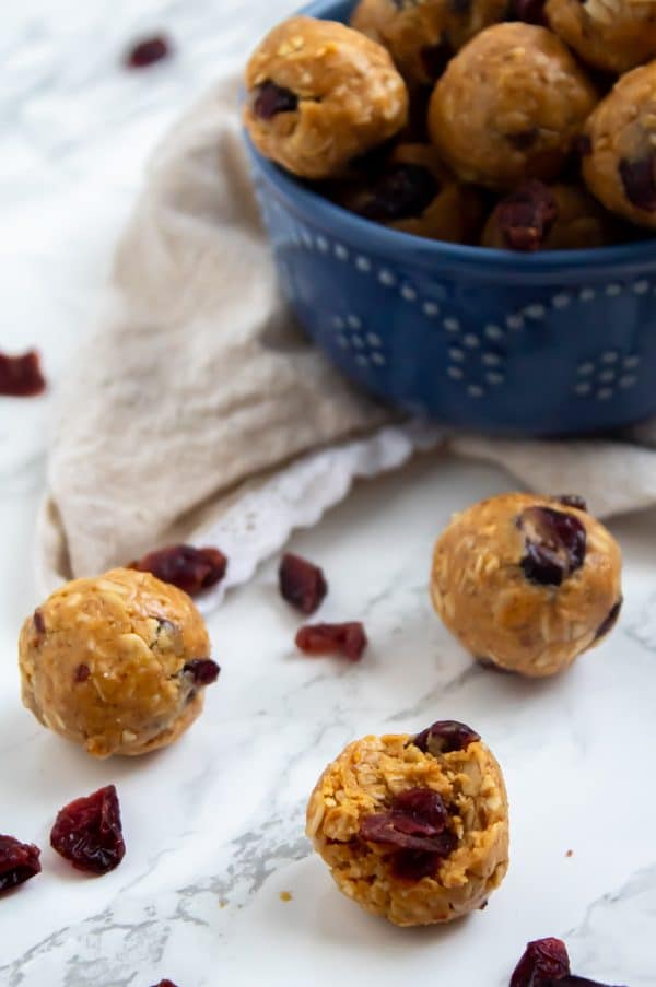 A blue bowl of Peanut Butter & Jelly Bites with one with a bite taken out.