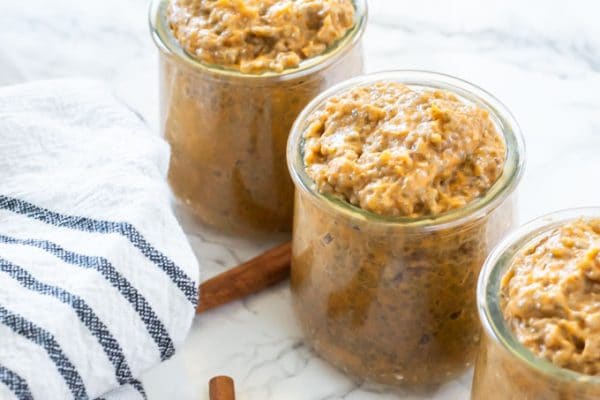 pumpkin chia pudding in small glass jars lined up diagnoally