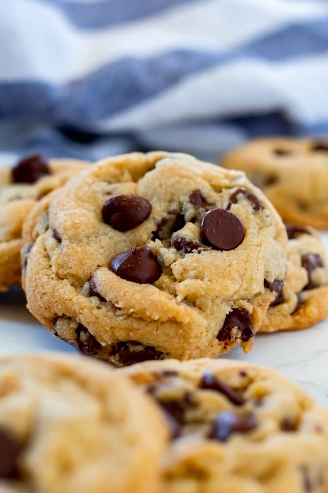 a gluten-free chocolate chip cookie propped against other cookies