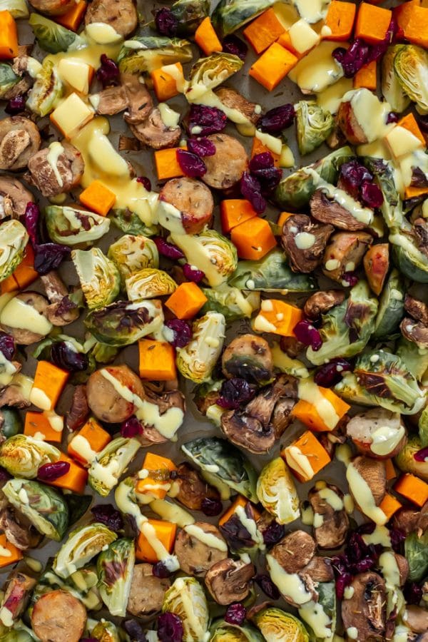 roasted butternut squash, brussels sprouts, mushrooms, chicken sausage with dried cranberries and a honey mustard drizzle on a sheet pan