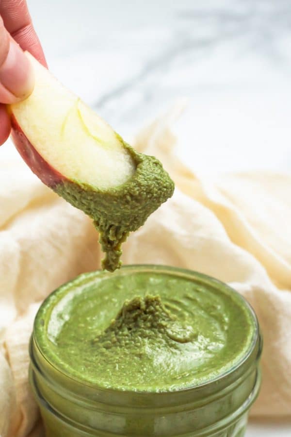 Dipping an apple slice in pumpkin seed butter.