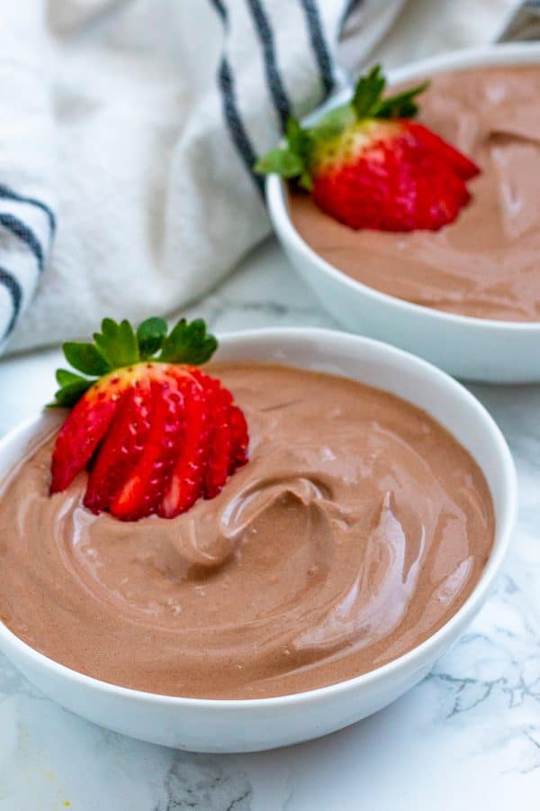 white bowls of chocolate yogurt with strawberry garnish