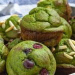 green spinach banana muffins on a metal tray - some with almonds, some plain, some with blueberries