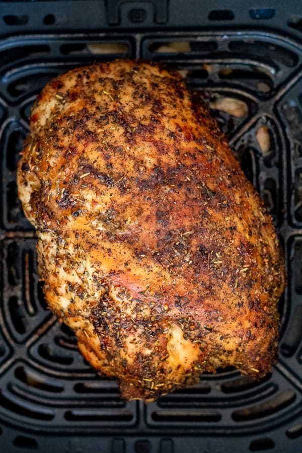 a whole air fryer turkey breast, cooked golden brown in the air fryer basket