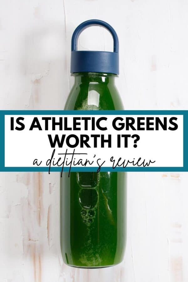 A glass water bottle full of green juice with text overlay that says "Is Athletic Greens Worth it? A dietitian's review"