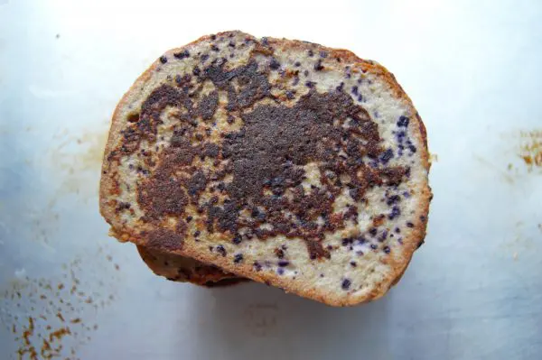 Overhead shot of a stack of blueberry French toast, like French toast but with tiny purple speckles from the blueberries blended into the egg mixture.