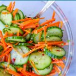 a glass bowl of crispy, fresh Asian-inspired carrot and cucumber salad