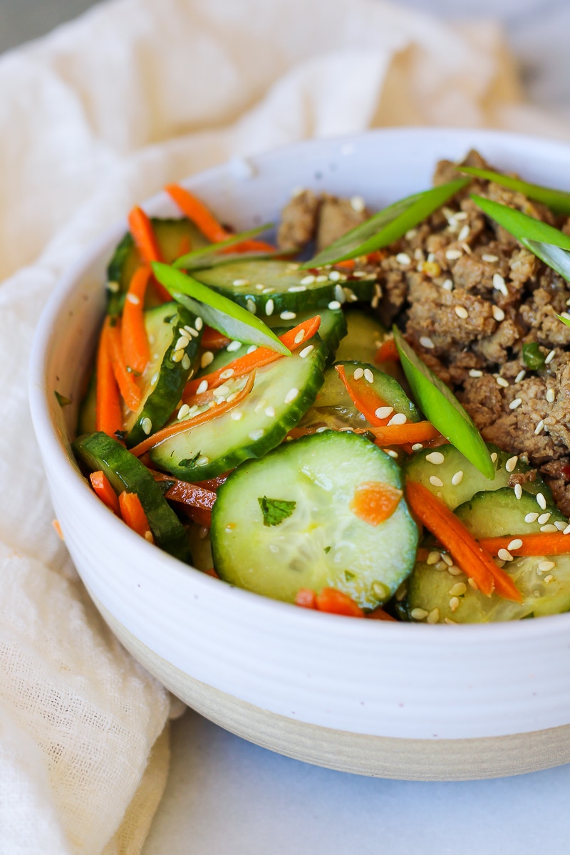 a bowl of carrot and cucumber salad, next to korean ground turkey over rice