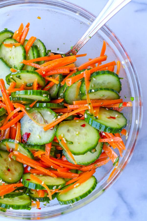 a glass bowl of crispy, fresh Asian-inspired carrot and cucumber salad