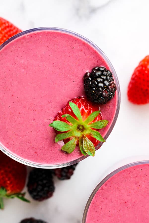 a strawberry banana blackberry smoothie garnished with fresh berries