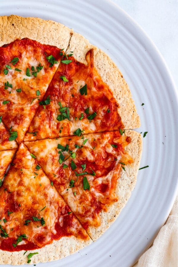 overhead shot of crispy air fryer tortilla pizza slices topped with fresh parsley