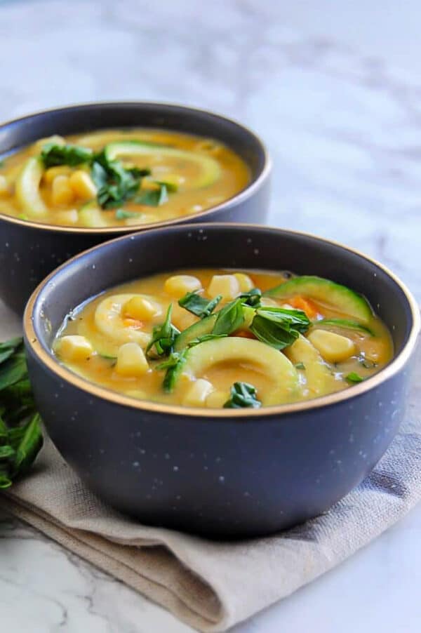 creamy zucchini corn chowder in small black bowls