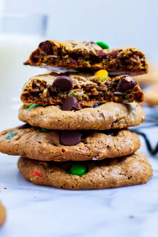 stack of gluten free monster cookies with one broken open on top