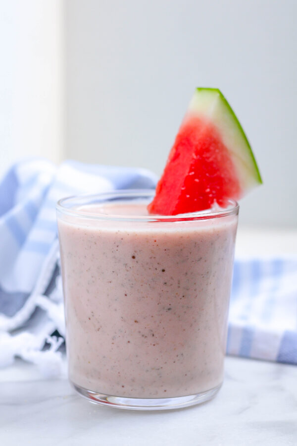 banana watermelon smoothie in a glass with a watermelon garnish