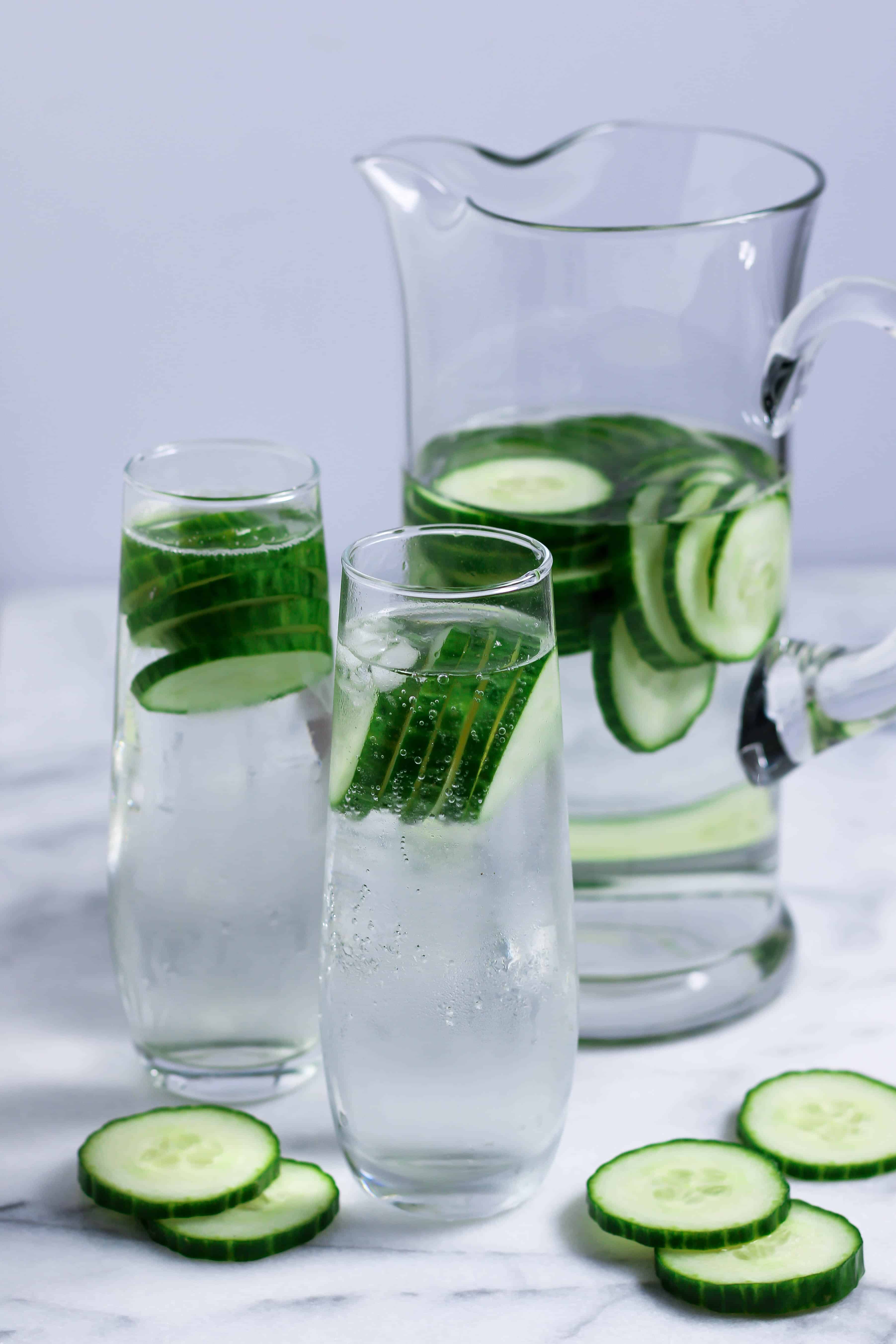 a pitcher and two glasses of cucumber infused water