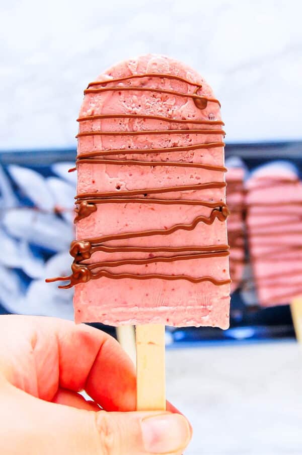 a chocolate drizzled creamy cherry popsicle