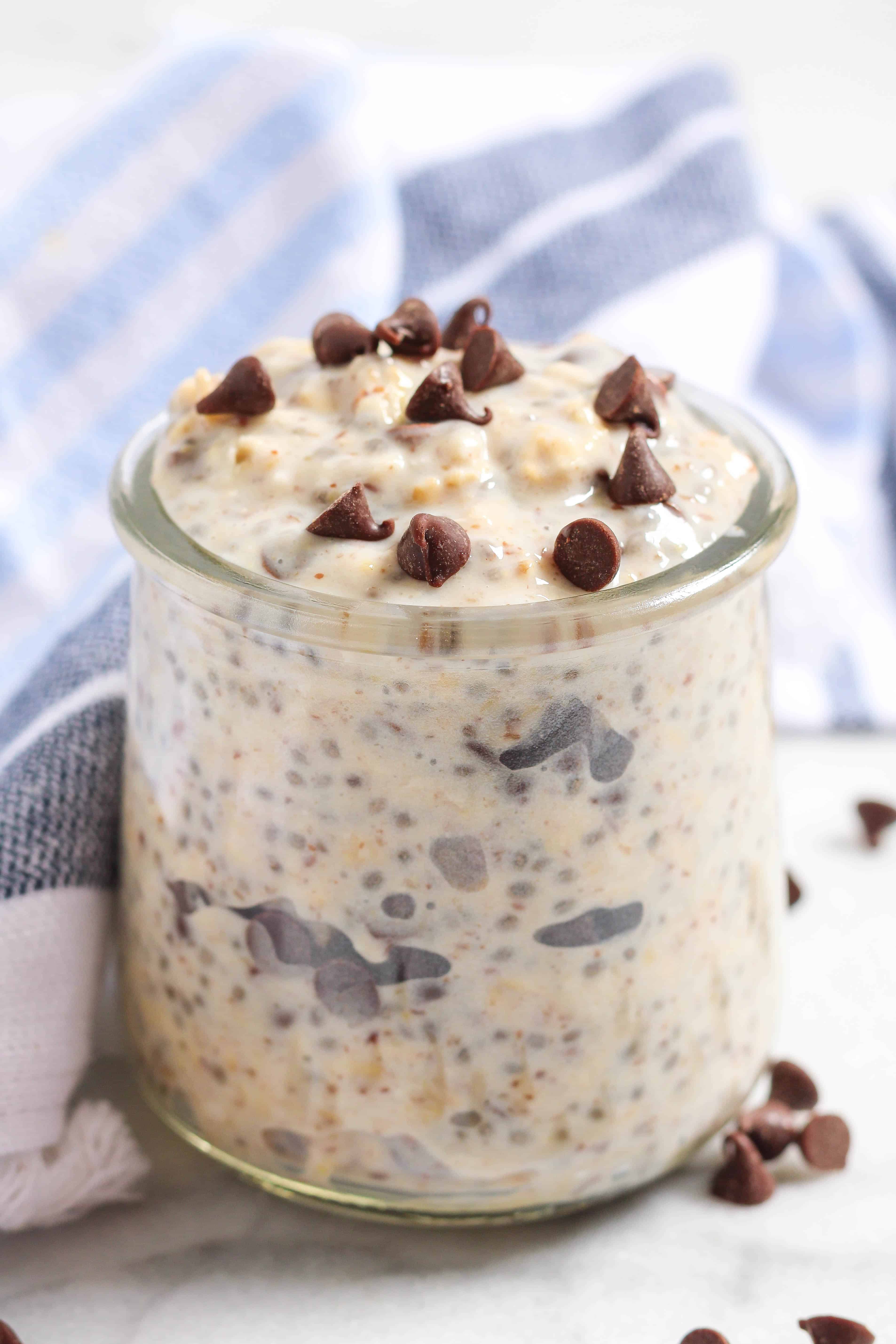 blue and white kitchen towel behind a small glass jar of chocolate chip cookie dough overnight oats