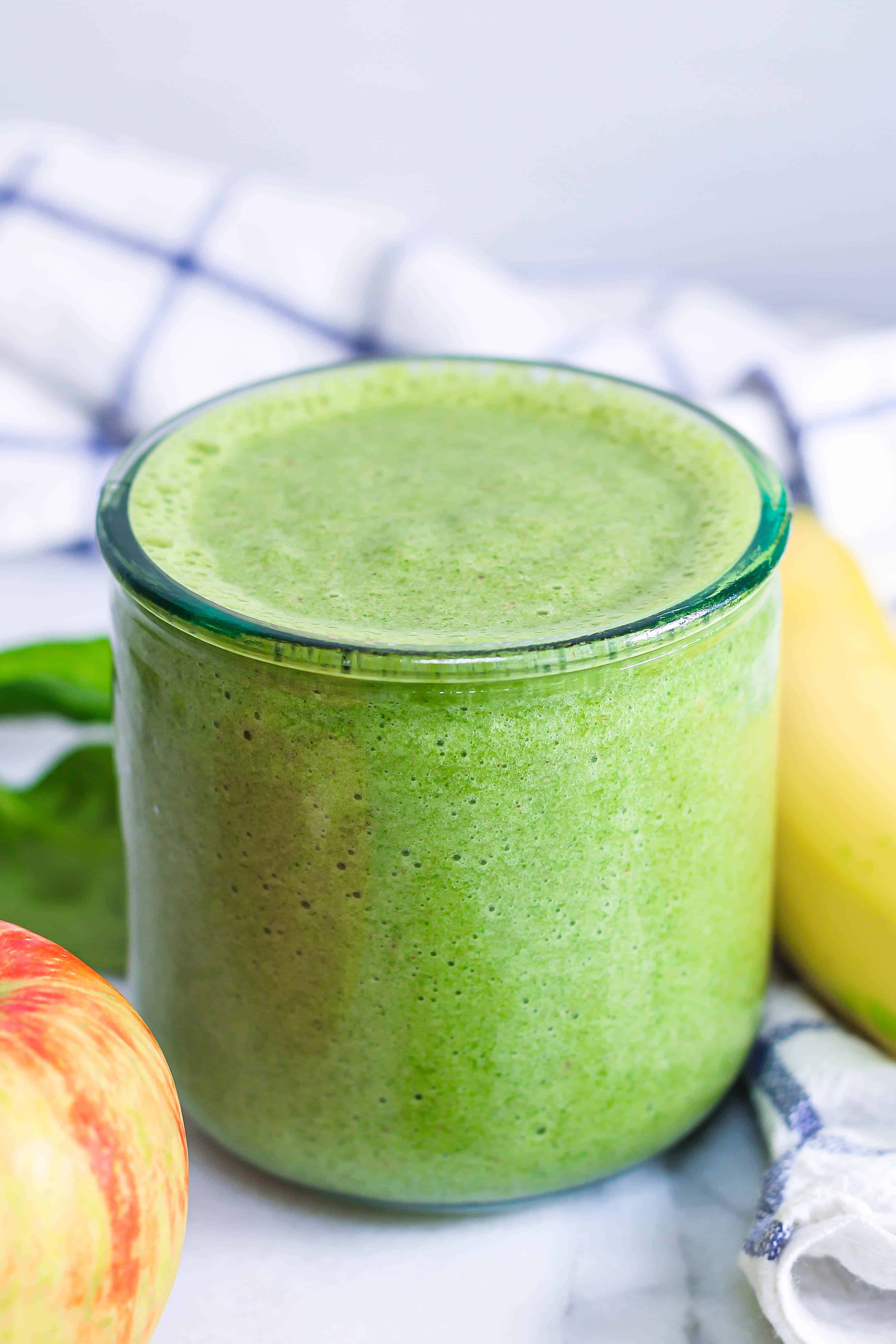 a glass of green spinach banana apple smoothie