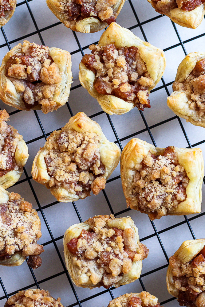 mini apple crumble tarts on a black cooling rack