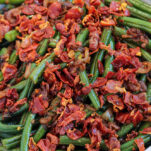 a bowl of tender green beans, caramelized shallots, and crispy prosciutto for prosciutto green beans