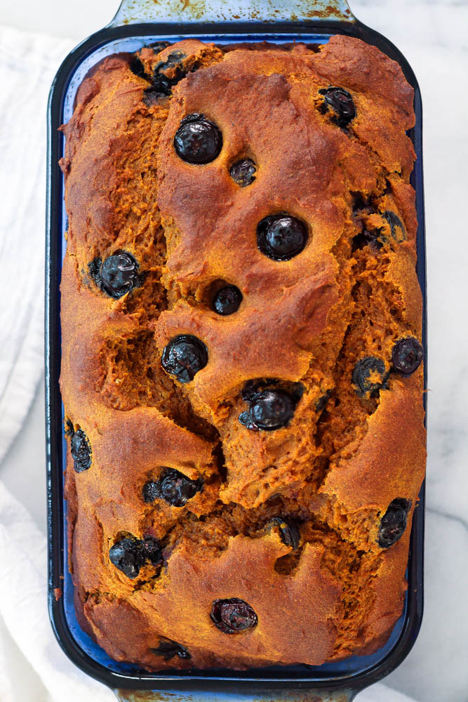 a blue glass pan with pumpkin blueberry bread