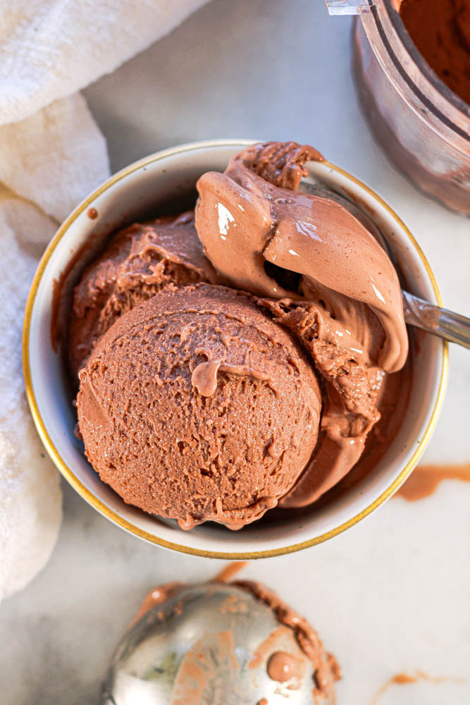 chocolatey ninja creami protein ice cream in a white bowl with gold rim