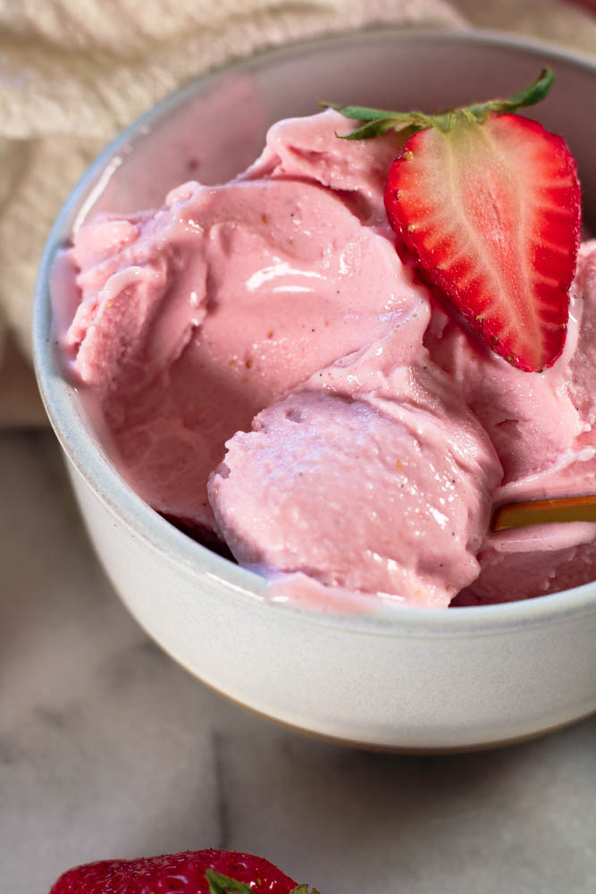 cottage cheese strawberry ice cream in a stoneware bowl
