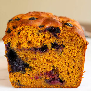 a cross section of a loaf of pumpkin blueberry bread