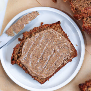 a slice of almond butter banana bread with almond butter on top