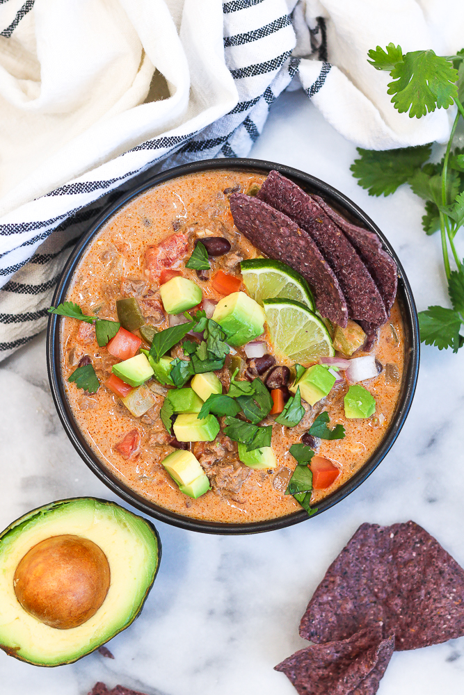 a bowl of creamy beef taco soup with lots of garnishes