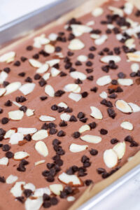 adding toppings to chocolate yogurt bark