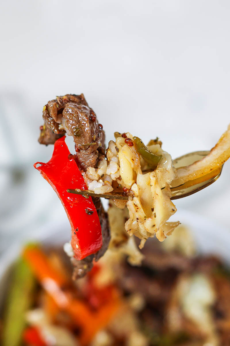 a fork with a bite of Philly Cheesesteak Rice Bowls