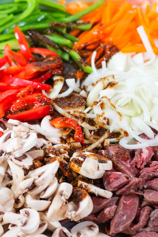 ingredients on a sheet pan to make philly cheesesteak bowls